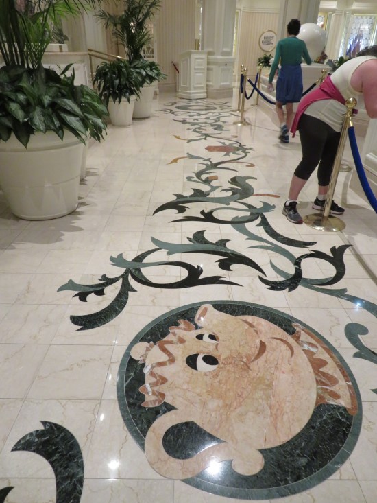 Fancy floor decor includes many angular swirls and a painting of Mrs. Potts from "Beauty and the Beast".