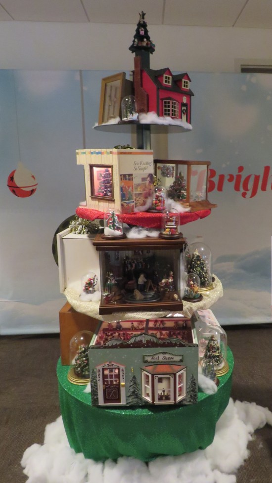 A bunch of dollhouses stacked in a Christmas tree shape.