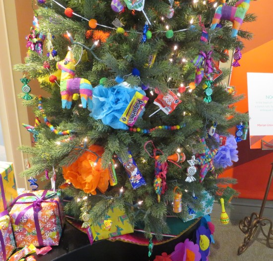 Christmas tree with lots of candy hanging from it, some in Spanish-language wrappers.