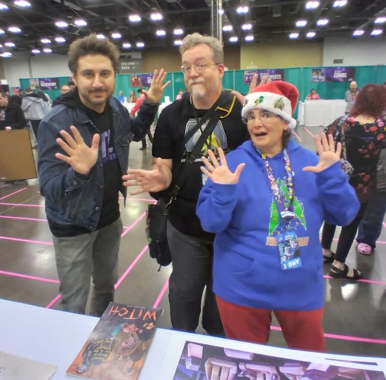 Us doing jazz hands with Terry Matalas on the other side of his table away from the curtains.