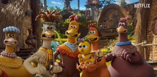 Five smiling Claymation chickens huddle around a freshly hatched chick in their hidden forest village.