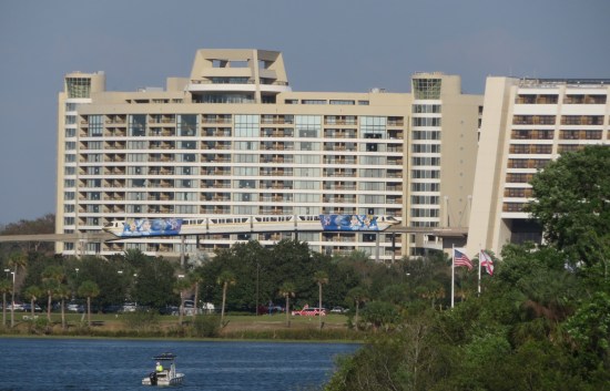 Large tropical hotel with a monorail running in front of it.