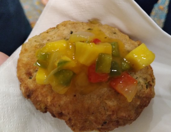 A fried crab cake with mango chutney on top.
