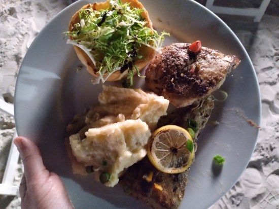 dinner plate, refer to caption. The quiche has greens on top.