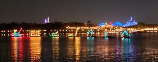 Boats carrying lights across nighttime water. Refer to caption for specifics.