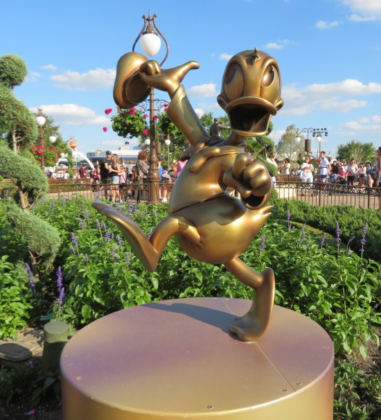 Gilded statue of Donald Duck, merrily strolling.