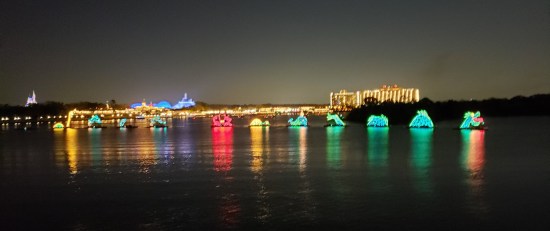 Boats carrying lights across nighttime water. Distant shapes include a sea serpent's head, dolphins, and an octopus.