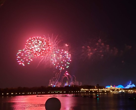 Distant fireworks over water. Three overlapping red balls.