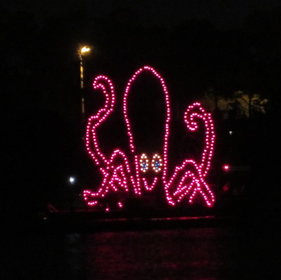 Closeup of light-show smiling red octopus.