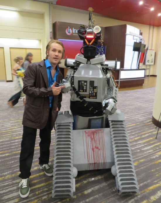 cosplay: robot Number Five with blood smeared on its base, chains and a bandolier.