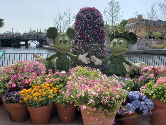 Topiary sculpture of Mickey and Minnie Mouse, their arms wide.