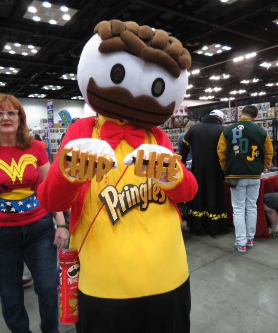 cosplay: Mr. Pringle with a gold chain and brass knuckles sporting the words "CHIP" and "LIFE".