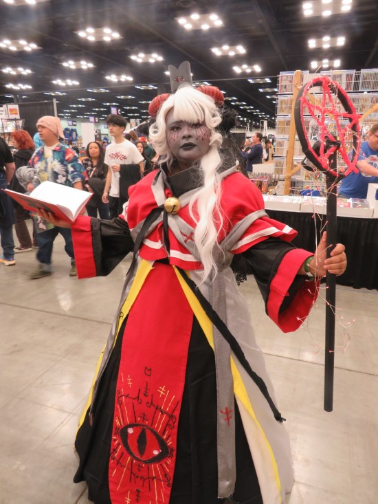 cosplay: red robe with white and yellow trim, crosses and a giant Sauron eye. Red pentagram staff and red spell book.