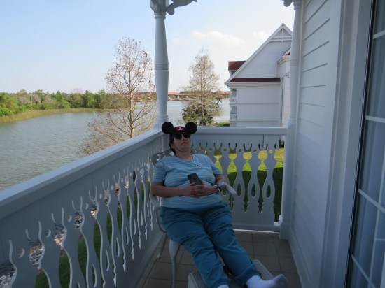 My wife asleep in a balcony chair, phone clutched in her hands. Beyond her is the Seven Seas Lagoon.