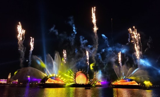 yellow gates, blue smoke, white fireworks stream upward wobbly.