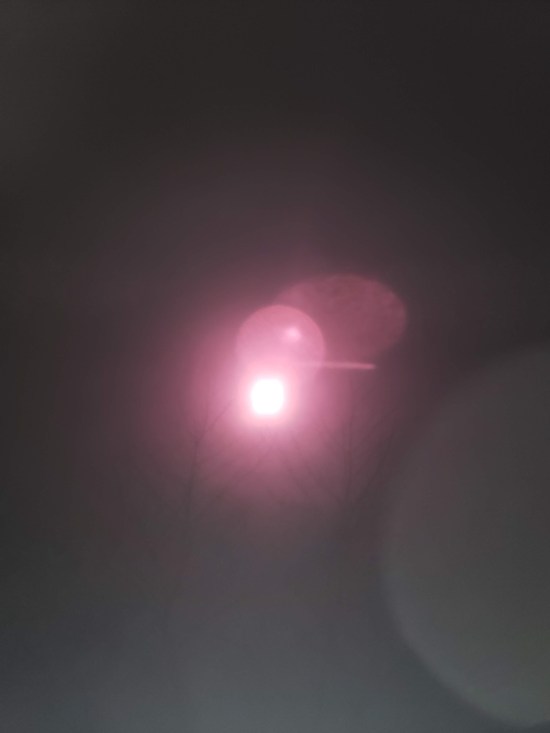 The sun looks purple when shot through plastic lenses of eclipse glasses.