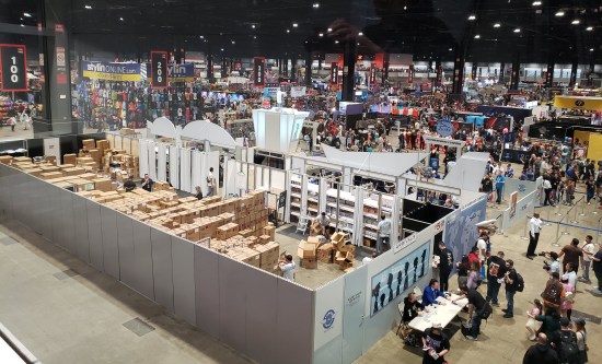 Bird's-eye view inside the Funko booth from the fourth floor. Tons of boxes filled with goodies, employees moving them here and there.