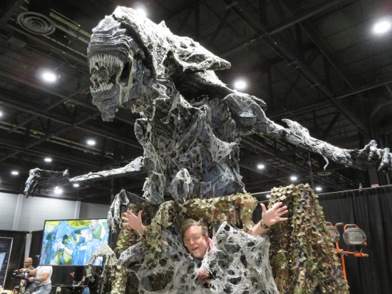 Me doing jazz hands inside fake Alien webbing beneath a looming Alien Queen statue at least 15 feet tall.