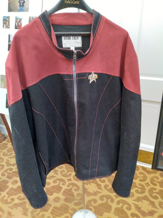 red and black Star Trek jacket with a combadge pinned to the chest.
