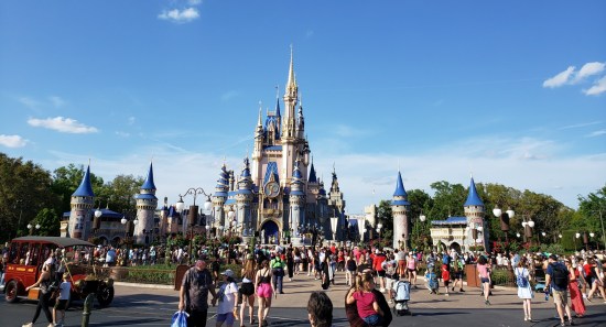 Hundreds of guests walking up to the fancy magic castle on a bright spring day.