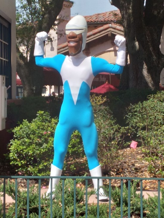 Frozone cast member flexing his biceps in front of bushes.