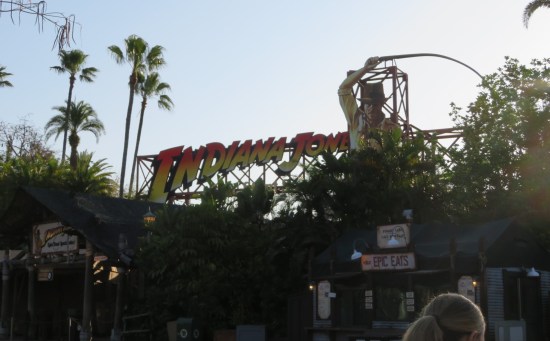Entrance to Indiana Jones outdoor amphitheater. Many trees block most of the view except the tall Harrison Ford sign.