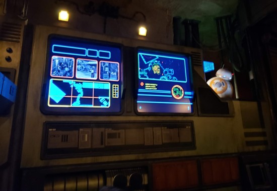 Space supercomputer with displays showing fake CCTV footage and blue maps.