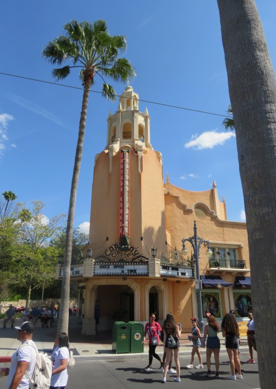 Tall, thin theater of vaguely Spanish architecture. Marquee features "Once Upon a Time". Theater name is obscured, something like Caraway Circle.