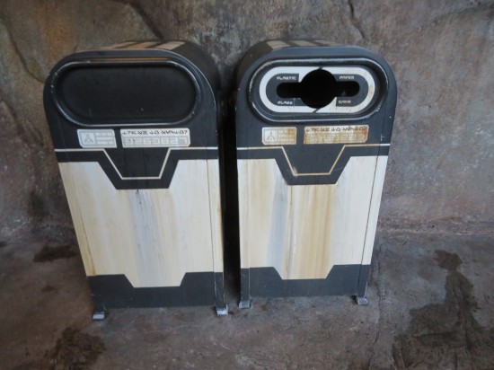 Two black-and-white trash cans (one of them for recyclables) against a cave wall. Labels written in Star Wars alien code.