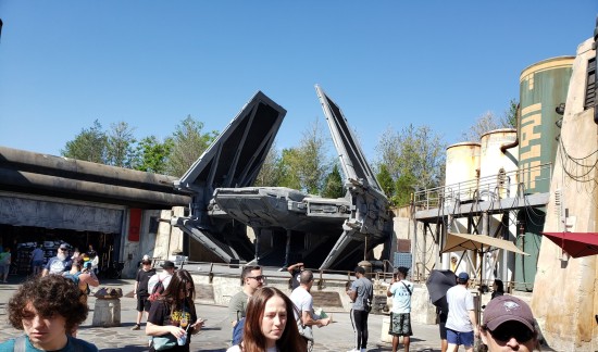 Large black spaceship with vertical wings parked in the middle of a pretend rock canyon.
