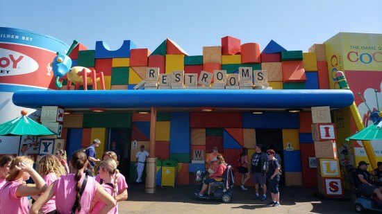 Restroom exterior, fake-built from giant wood building blocks. The "restrooms" sign is made of Scrabble tiles. 