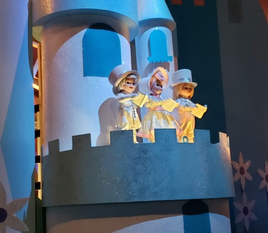 cutesy singing animatronic figurines, a Finland trio dressed in all white on a castle balcony.