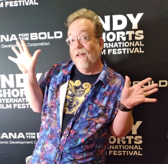 Me doing jazz hands in front of wall covered in Indy Shorts Film Festival logos and other related partners.