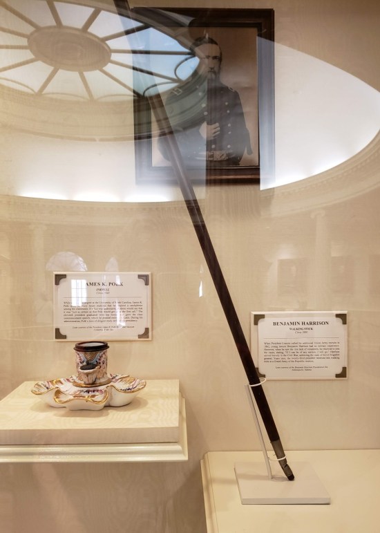 Vitrine with fancy white inkwell and walking stick. Rotunda skylights reflect on the glass.