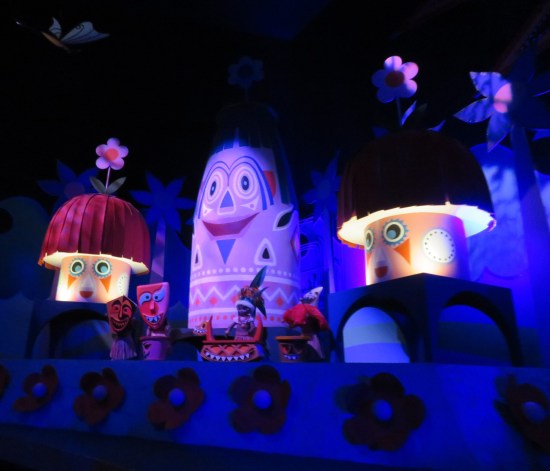 Three cutesy singing animatronic figurines with tribal face paints, two mushroom-shaped and one shaped like a thumb. Everything's blue and purple.