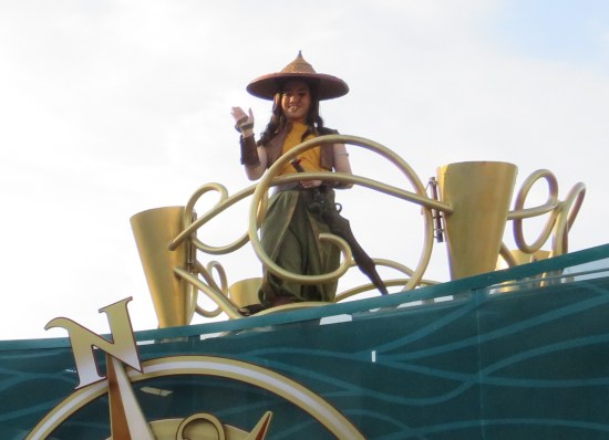 Raya waving from atop a float.
