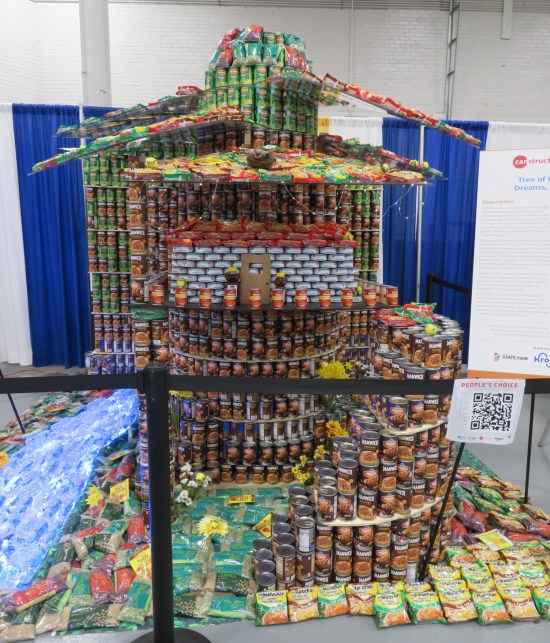 Tree and treehouse made of cans and boxes of corn flakes.