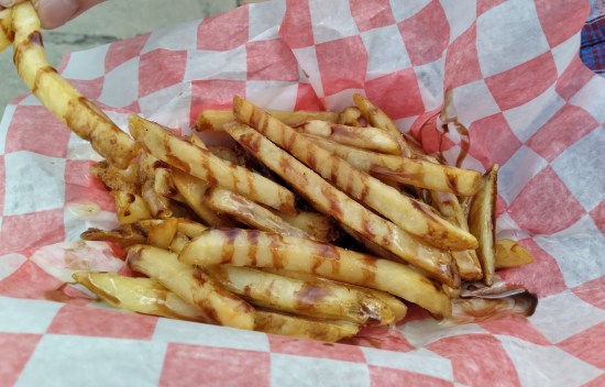 An order of French fries with two kinds of chocolate drizzled on them.