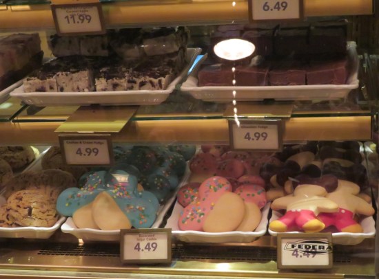Bakery display with cookies shaped like Mickey Mouse and normal-shaped fudge blocks.