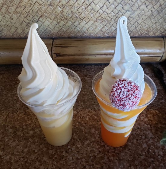 Two Dole Whip floats sitting on a shaded wooden shelf, refer to caption.