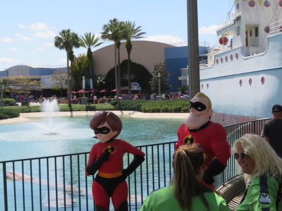 Elastigirl and Mr. Incredible cast members posing by the lagoon fence.