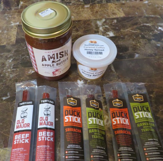 jar of apple butter, tiny tub of caramel coffee honey spread, and six jerky sticks.