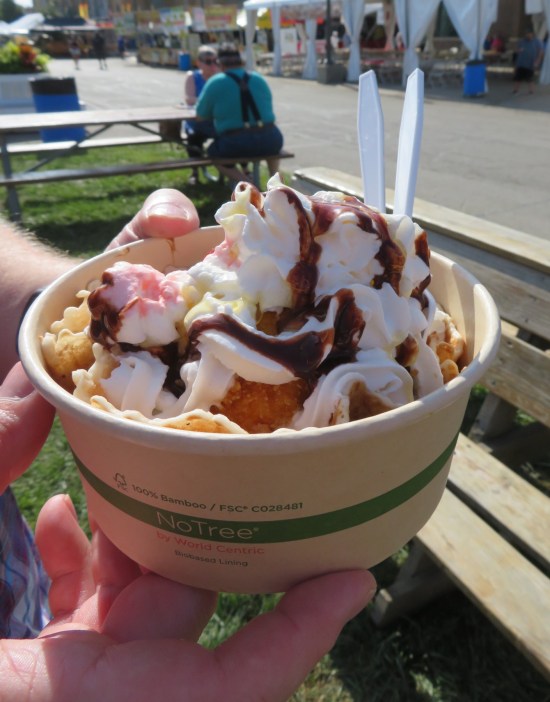 Ice cream sundae barely distinguishable from any other. The cornflake breading is barely visible through several ounces of whipped cream. 