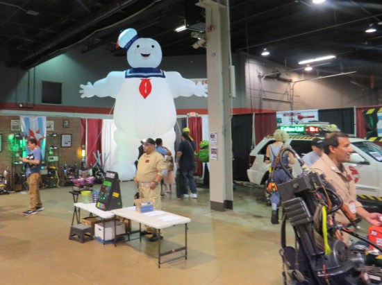 Ghostbusters fan group area with inflatable Mr. Sta-Puft, vehicles and props.