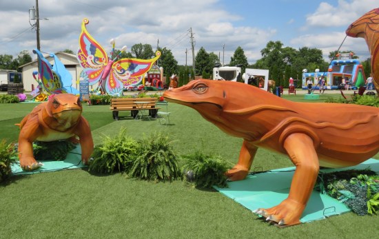 Two orange Komodo dragons statues at a right angle from each other.