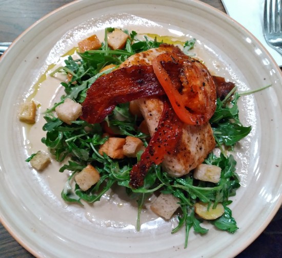 Fish with bacon strips on it.