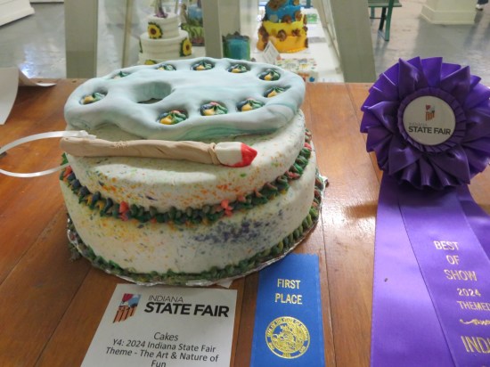 Nice cake, top layer shaped like a painter's palette and paintbrush.