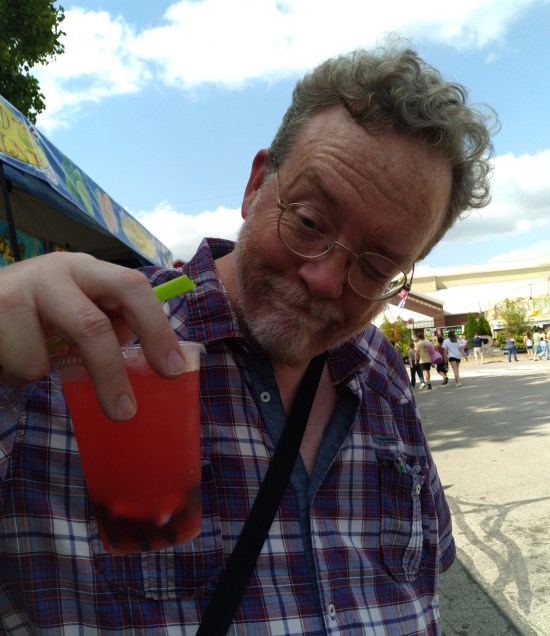 Me looking askance at a red drink with gelatinous globs settled in the bottom.