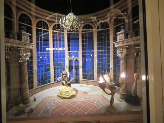 Window display of Belle and the Beast's famous ballroom dance. In the foreground are a giant Lumiere and Plumette.