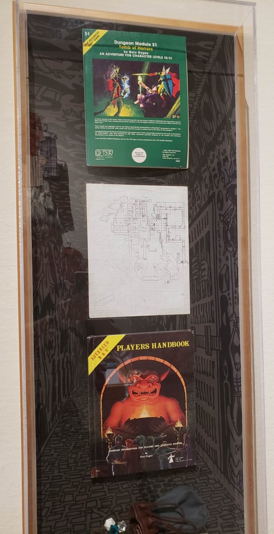 Advanced Dungeons and Dragons materials: "The Tomb of Horrors" module, a map hand-drawn on graph paper, and the Players' Handbook.